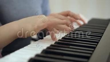 年轻的女人教小女孩<strong>弹钢琴</strong>。